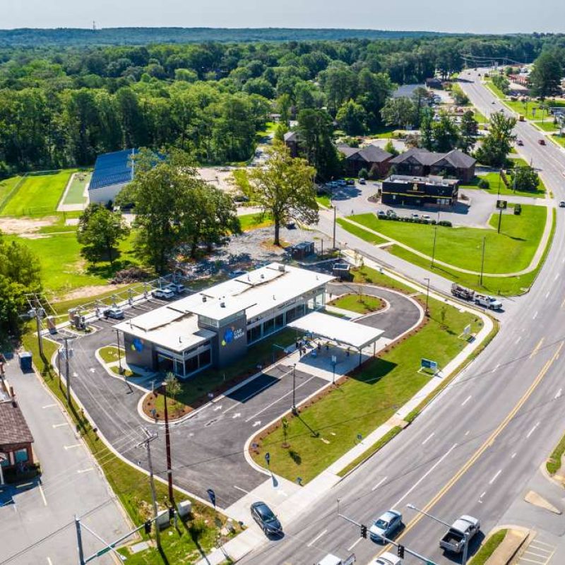 Overhead view of Splash Car Wash Bryant location placement near buildings, highways, and forested areas.