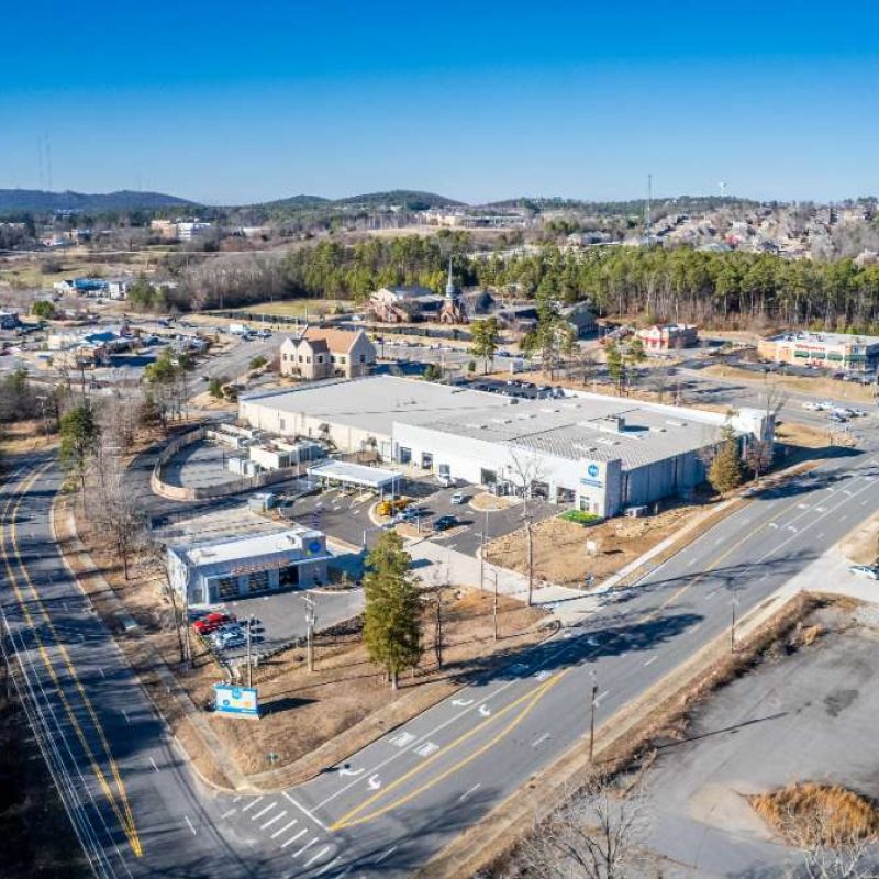 Aerial view of Splash Car Wash West Little Rock location, surrounded by highways, smaller buildings, and forrested areas.